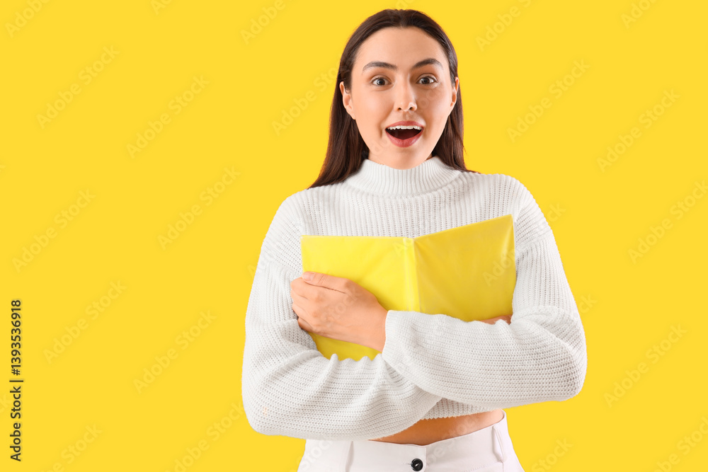 Surprised young woman with book on yellow background Surprised young woman with book on yellow background