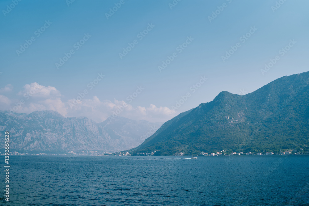 Bay of Kotor at the foot of a high mountain range in a light haze. Montenegro Bay of Kotor at the foot of a high mountain range in a light haze. Montenegro