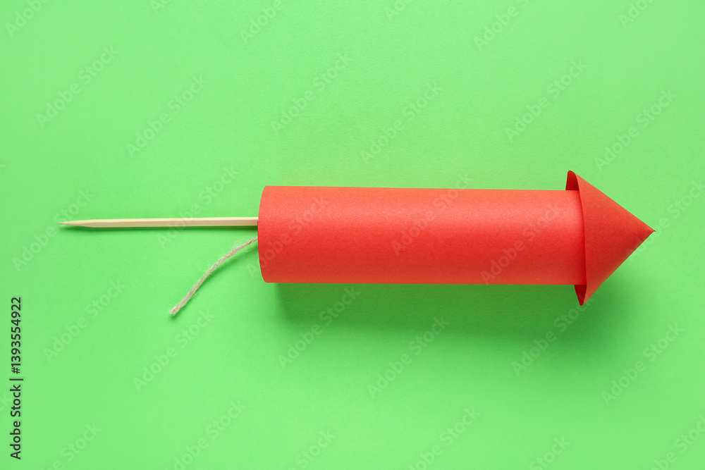 Red firework rocket on green background