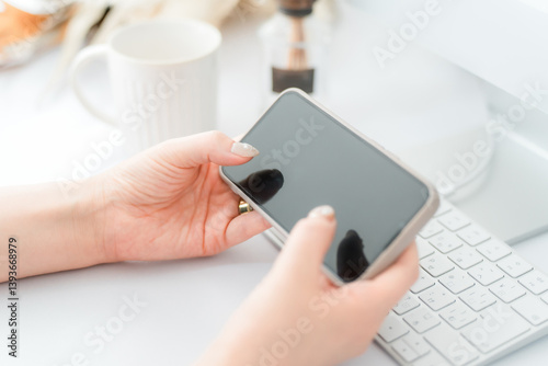 スマホ・スマートフォンの横向きの画面を見るネイルをした女性
 photo
