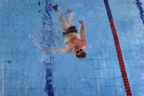 Man swimming in a pool back stroke