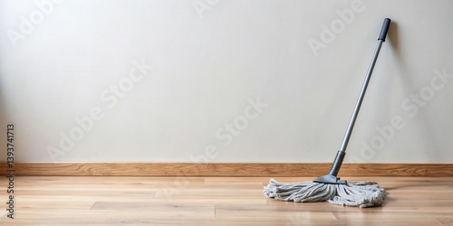 Obraz na płótnie A cleaning mop rests against a light wall next to a wooden floor, ready for household chores w salonie