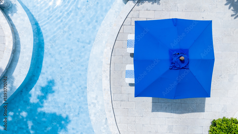 Top view swimming pool blue water in summer with umbrella pool and deck beach chair, Empty swimming pool with sunbed and umbrella pool in resort hotel for vacation leisure, Summer vacation holiday.