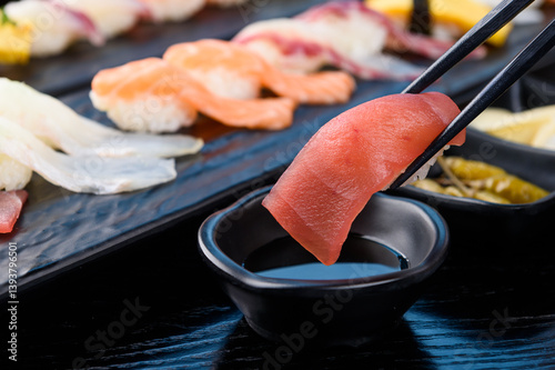 Lightly dipping the tuna sushi in soy sauce
