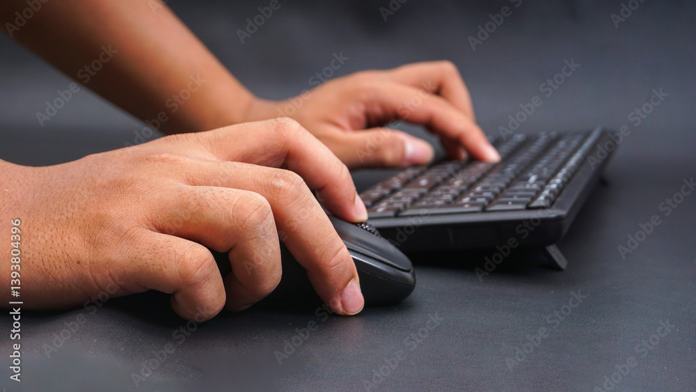 Man hand typing on computer keyboard and holding computer mouse isolated on black background Man hand typing on computer keyboard and holding computer mouse isolated on black background