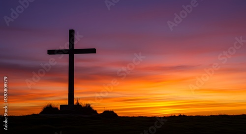 A wooden cross stands on a hill silhouetted against a dramatic sunset sky in shades of orange, purple, and red, symbolizing faith, hope, and spiritual reflection in nature.