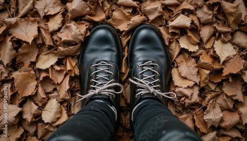 Obraz na płótnie Pair of boots standing in a pile of crunchy dry leaves, captured from above w salonie
