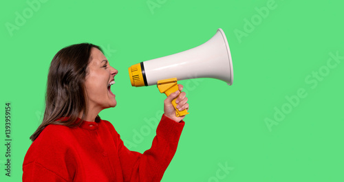 Photos Woman passionately shouting into a megaphone against a bright green background d