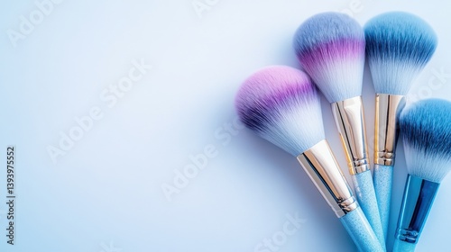 Beautifully Arranged Colorful Makeup Brushes on a Soft Blue Background for Beauty and Cosmetic Use