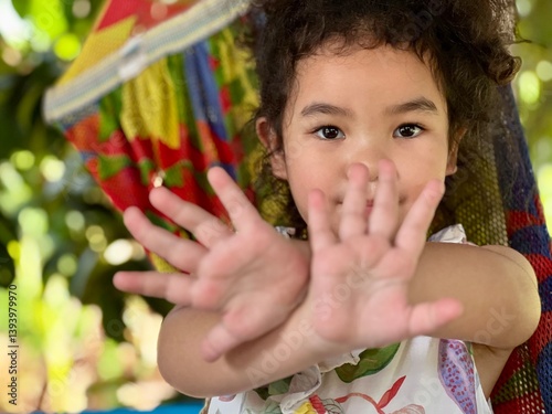 Portrait of a cute little girl having fun in a hammock