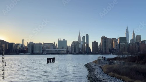 Horizontal video of the end of the walking trail in Long Island City and across the East River is the midtown Manhattan skyline at sunset.