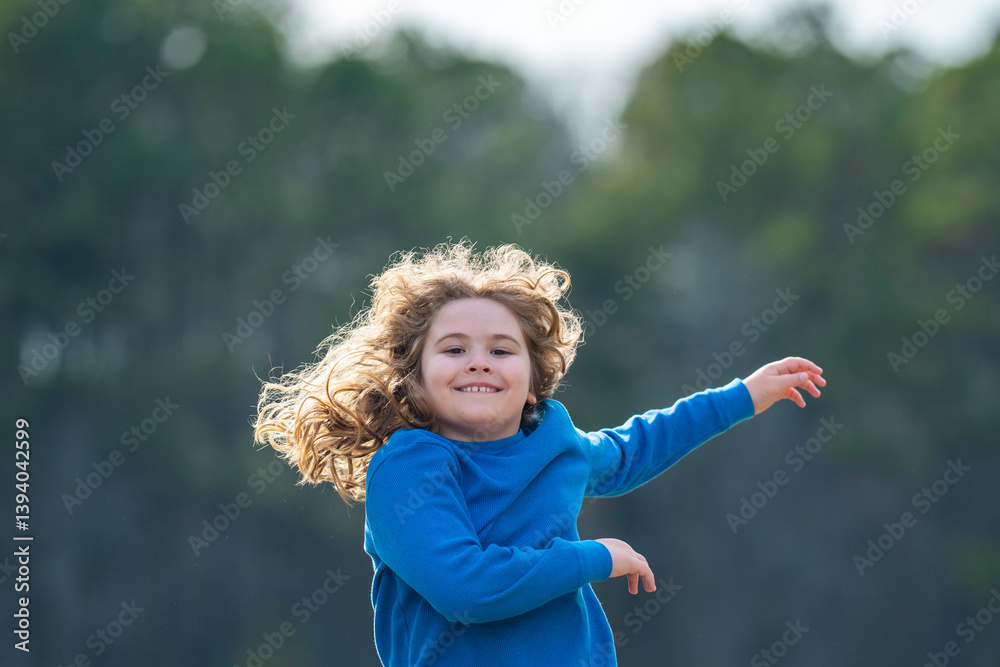 Fototapeta premium Child running on field. Happy kid running outdoors. Child jumping and running in nature. Kid running in a meadow. Summer fun for active child. Playful kid freedom. Free childhood in nature.