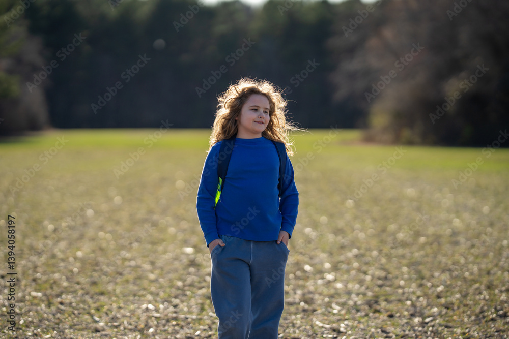 Fototapeta premium Kid in a daydream. Carefree childhood in nature. Dreamy kid. Thoughtful child. Little kid dreamer. Young mind full of imagination. Blonde kid thinking. Kids freedom. Calm and peaceful childhood.