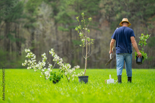 Worker planting seedling. Farmer growing plants in backyard. Man working on the farm. Agricultural work outdoors. Backyard gardening lifestyle. Soil preparation for planting. Planting tree in green