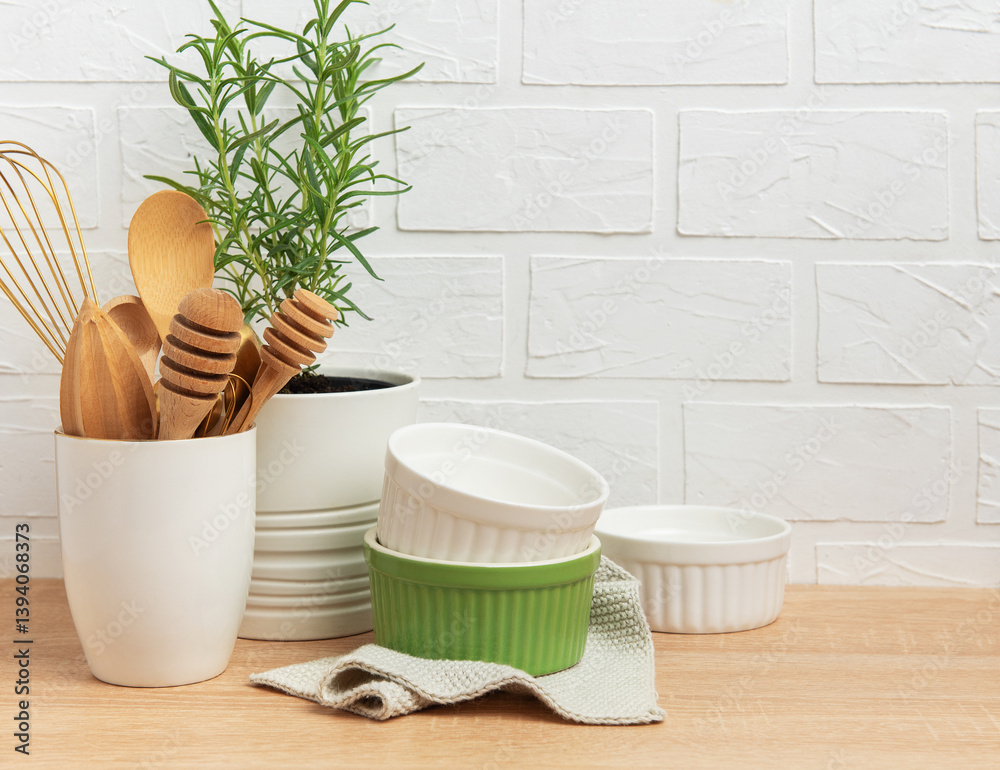 Kitchen utensils, rosemary plant, and ramekins creating a cozy culinary scene