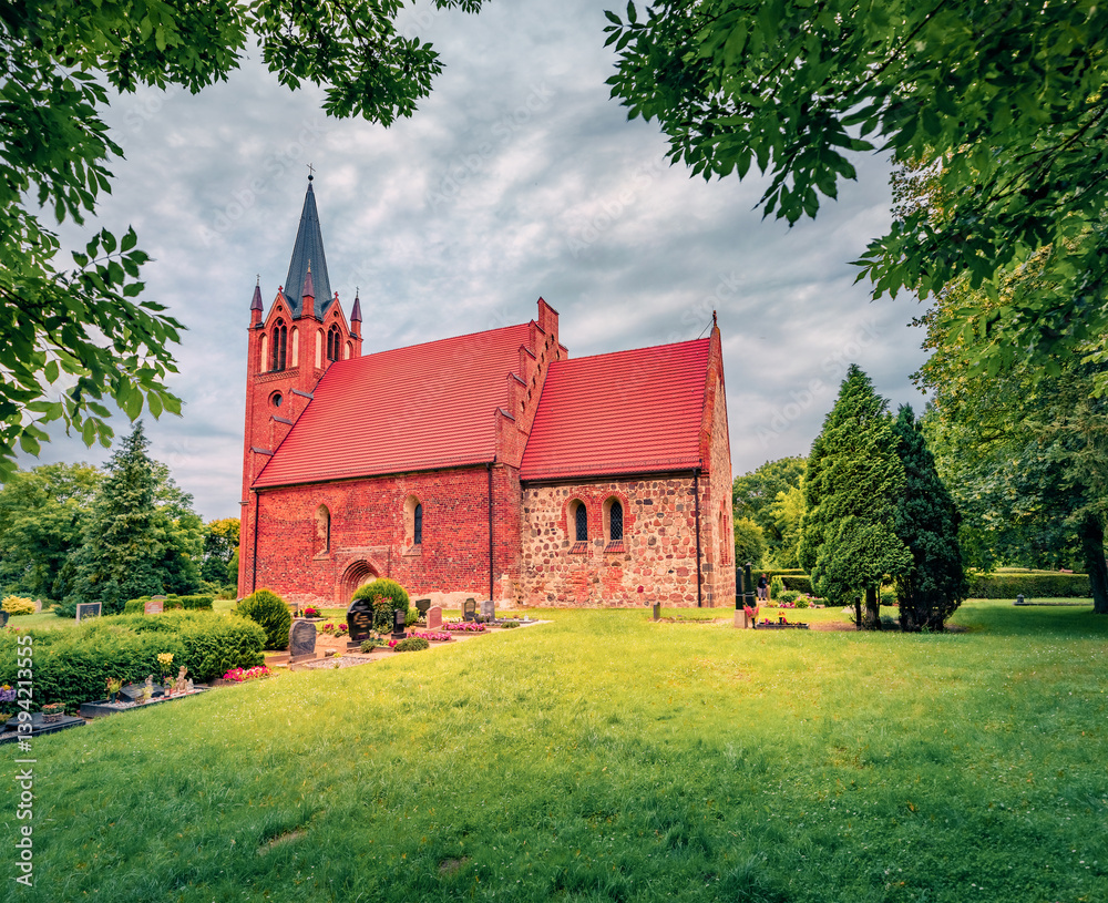 Adorable summer view of red briks St.-Johannis Church. Gorgeous morning cityscape of Kruckow village, Germany, Europe. Traveling concept background.