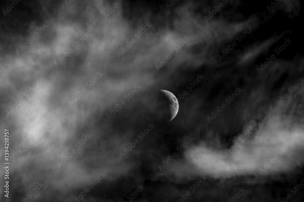 Crescent moon sits among dramatic cloudscape