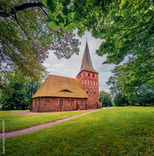 Obraz na płótnie Fresh greenscene of beautiful old church of Polish Queen among foliage trees. Majestiv morning view of Iwiecino village, Koszalin County, West Pomeranian, Poland, Europe. Travel the world. w salonie