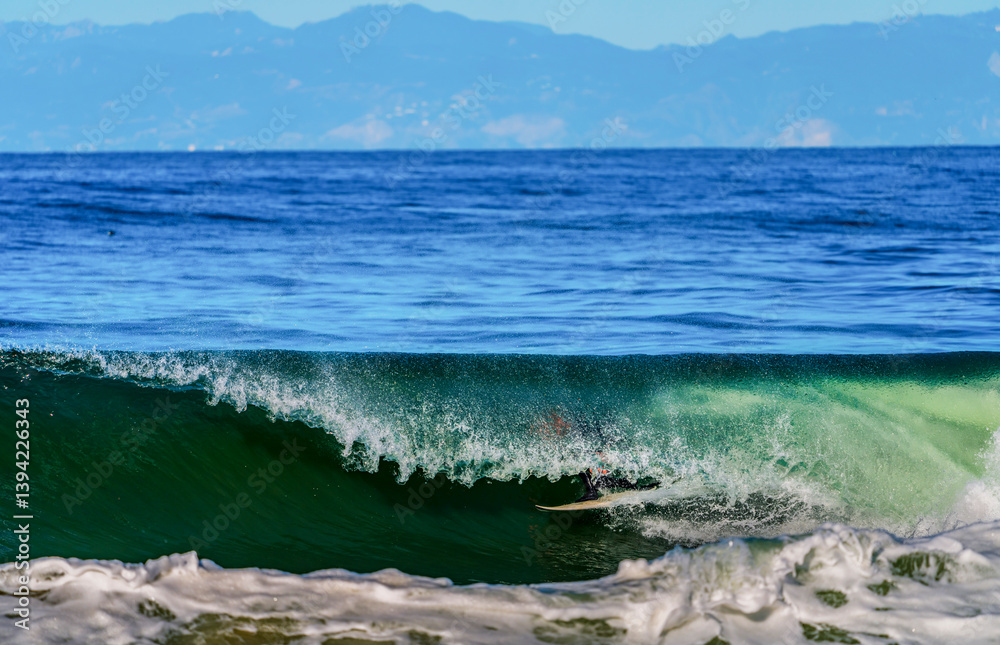 Surfer's feet and board showing through the closing of a large wave