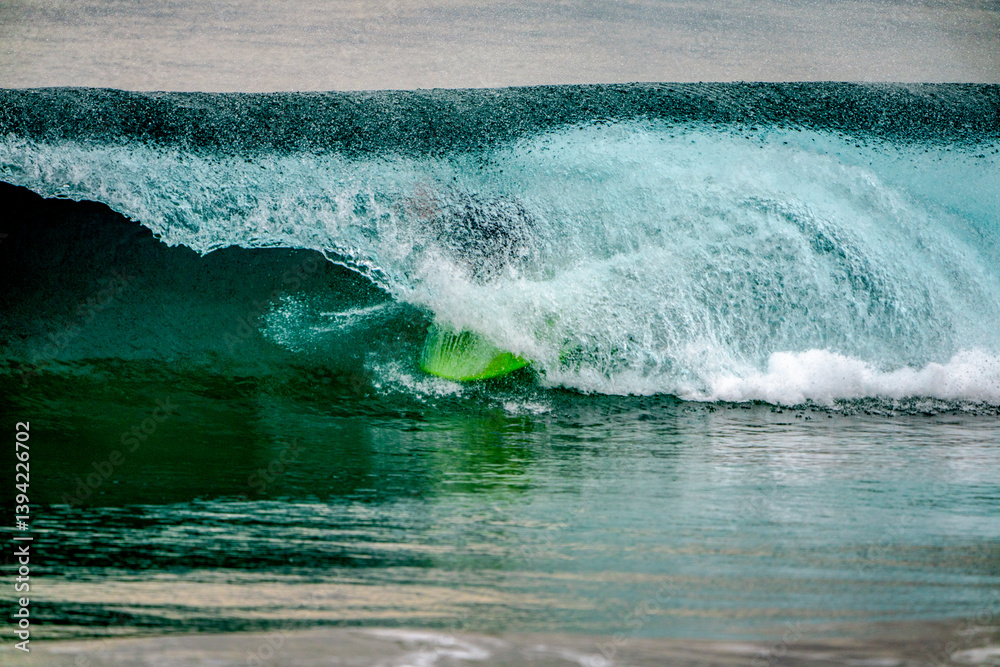 Surfer's feet and board showing through the closing of a large wave