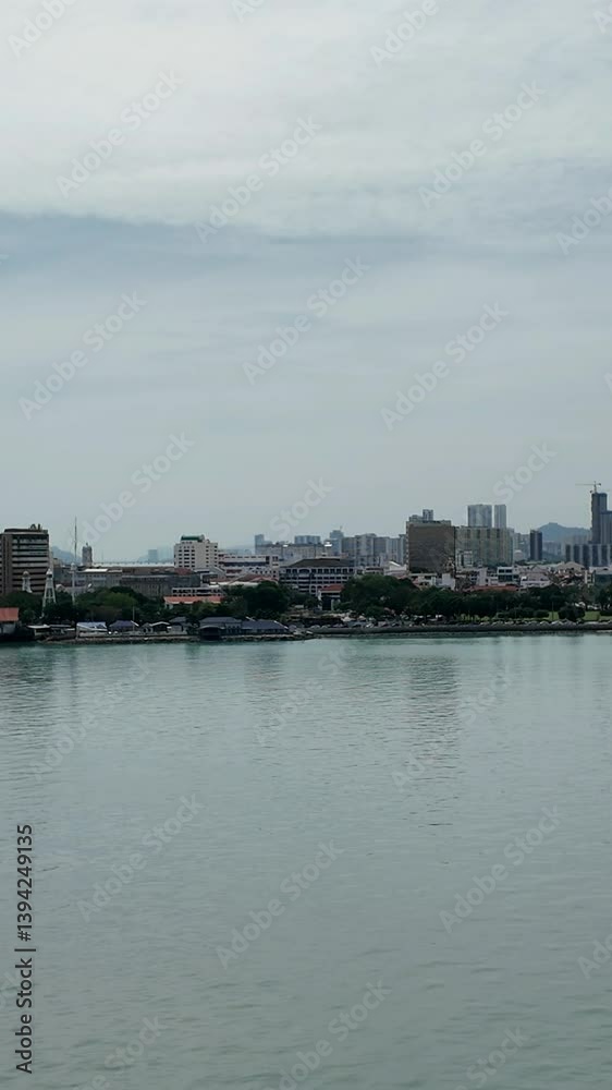 Swettenham Pier Cruise Terminal, Penang, Malaysia and vertical view of shoreline, buildings, condos, and mountain landscape in background. Swettenham Pier Cruise Terminal, Penang, Malaysia and vertical view of shoreline, buildings, condos, and mountain landscape in background.