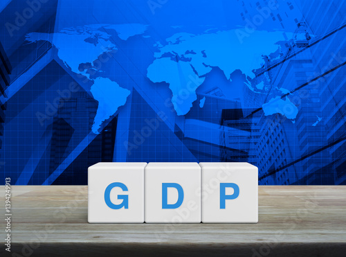 Fototapeta Naklejka Na Ścianę i Meble -  GDP acronym on white block cubes on wooden table over world map, office city tower and skyscraper, Gross domestic product concept, Elements of this image furnished by NASA