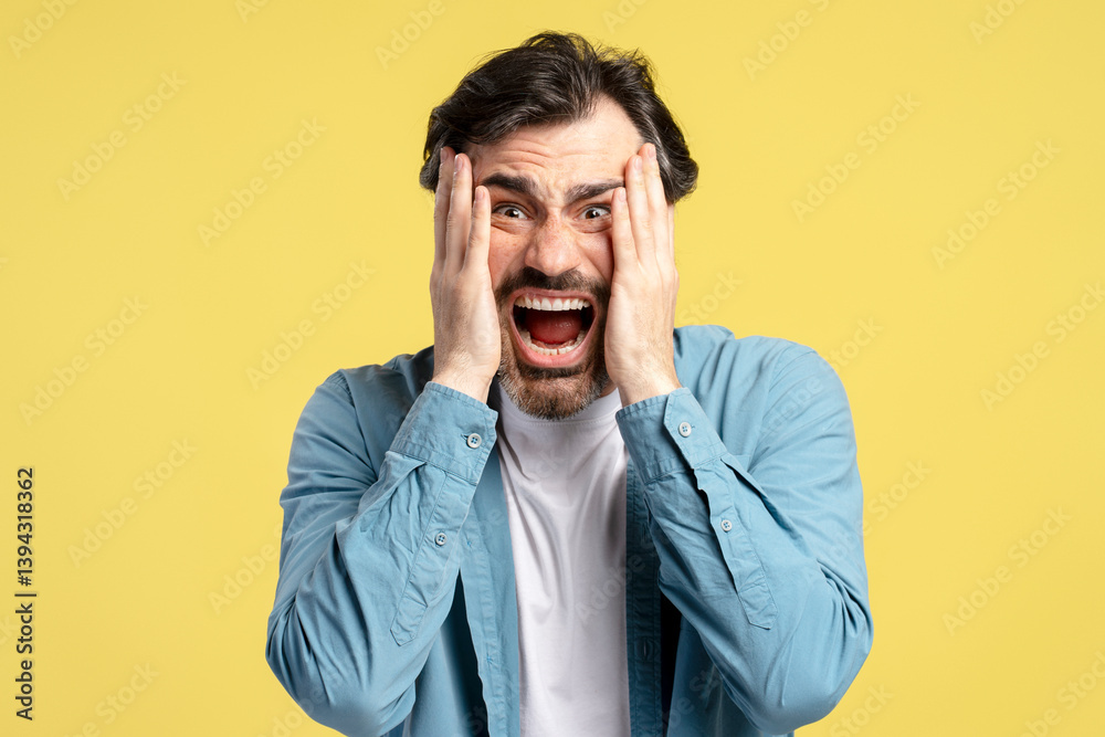 Shocked man screaming and holding face in despair on yellow background