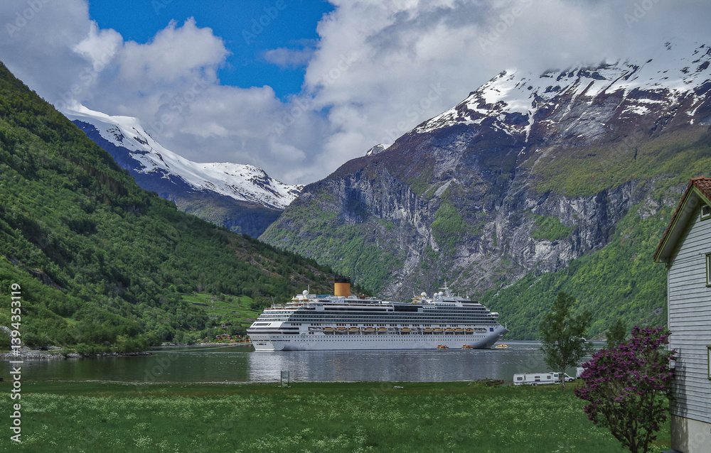 Modern mega cruiseship cruise ship liner Favolosa in Geirangerfjord with panoramic views of Geiranger and the breathtaking mountain scenery and fjord landscape nature during Norway cruising