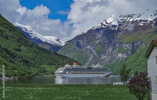 Obraz na płótnie Modern mega cruiseship cruise ship liner Favolosa in Geirangerfjord with panoramic views of Geiranger and the breathtaking mountain scenery and fjord landscape nature during Norway cruising w salonie