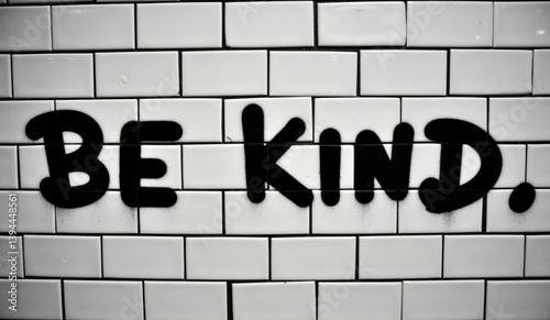 a brick wall with the words be kind written on it