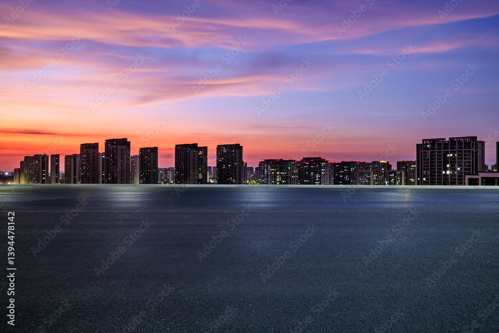 Evening cityscape silhouette under colorful sky with empty road