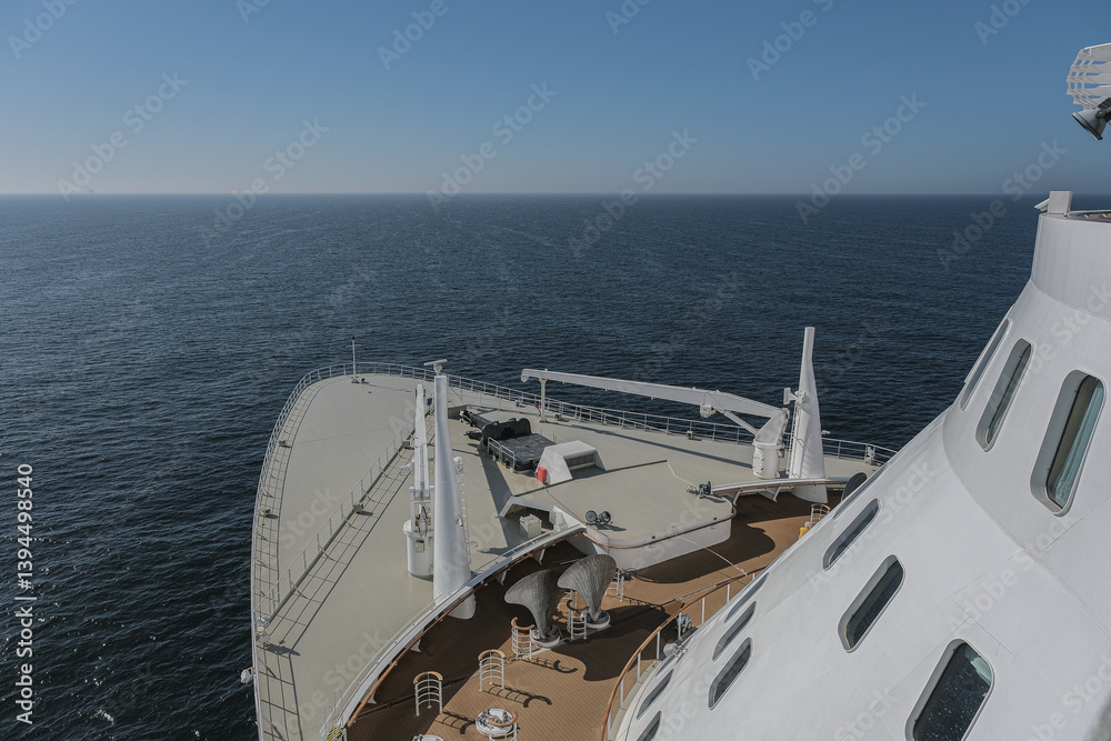 Views onto outdoor teak balcony terrace veranda promenade boat deck of ocean liner cruiseship cruise ship with chairs and loungers at sea during Transatlantic Crossing to New York on beautiful sun day
