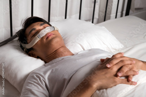 Man sleeping peacefully with CPAP nasal mask, used for treating snoring and obstructive sleep apnea (OSA). Promotes better breathing, sleep health, and nighttime respiratory therapy at home.