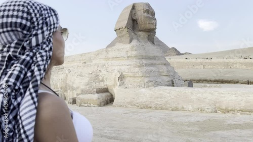 Capture a tourist enjoying the Giza Sphinx, a pharaonic monument on Egypt's Nile. Perfect for projects that transport viewers to the ancient pharaonic era.