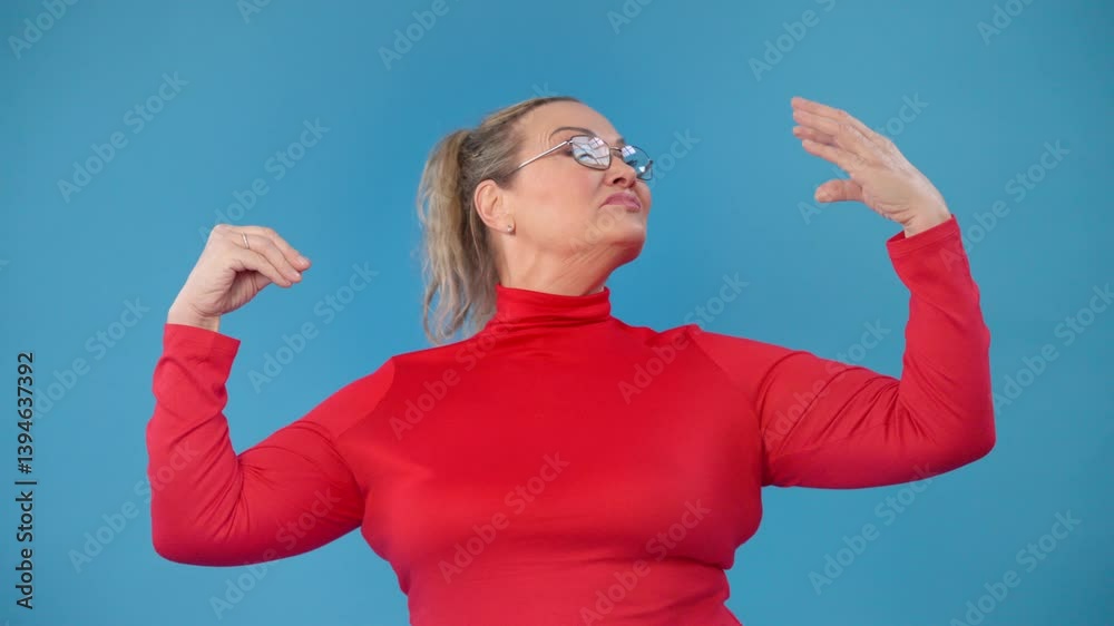 Confident woman in red long-sleeve top poses against a blue background, showcasing blah blah gestures