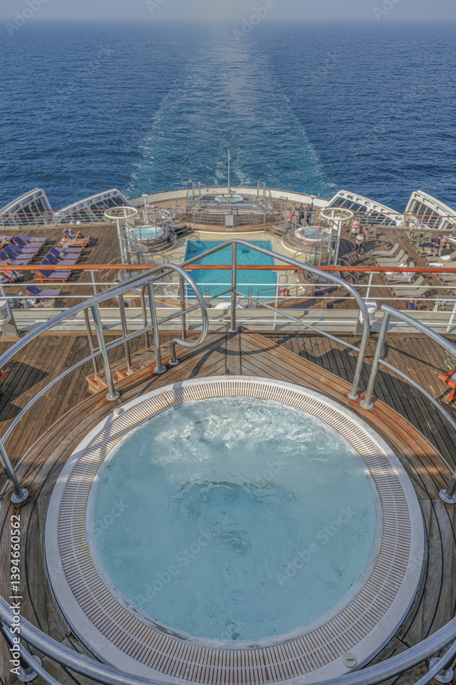 Views onto outdoor teak balcony terrace veranda promenade sun pool deck of ocean liner cruiseship cruise ship with chairs loungers at sea during Transatlantic Crossing to New York on beautiful sun day