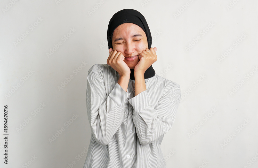 Surprised Southeast Asian woman wearing headscarf with wide eyes and open mouth. Shocked expression, studio portrait on white background, emotional and spontaneous reaction. Surprised Southeast Asian woman wearing headscarf with wide eyes and open mouth. Shocked expression, studio portrait on white background, emotional and spontaneous reaction.