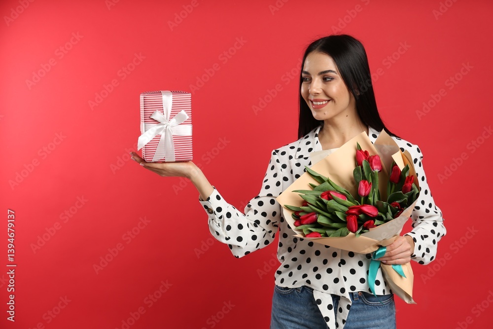 Happy woman with tulip flowers bouquet and gift box on red background. 8th of March celebration Happy woman with tulip flowers bouquet and gift box on red background. 8th of March celebration