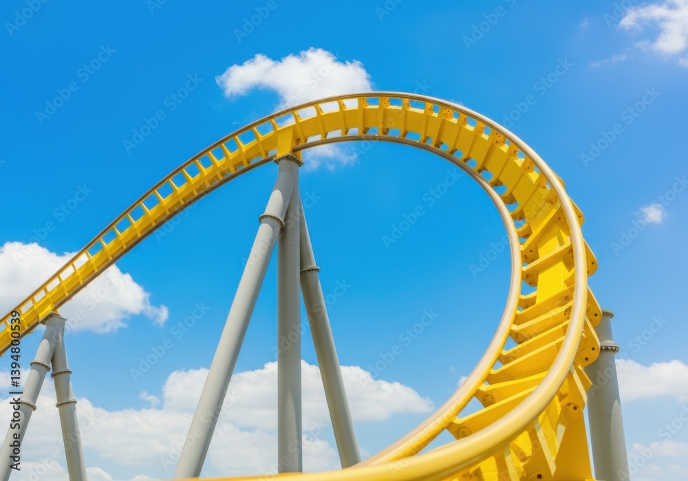 Yellow roller coaster loop against blue sky with clouds on a sunny day Yellow roller coaster loop against blue sky with clouds on a sunny day