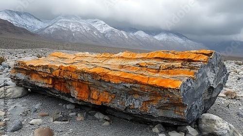 An orange-hued rock formation in a desert landscape. photo