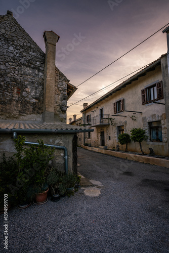 Fototapeta Naklejka Na Ścianę i Meble -  Romantic sunrise in tiny streets of small village in the countryside of Slovenian wild nature. Such a calm and peaceful moment when the sun rises above the horizon.
