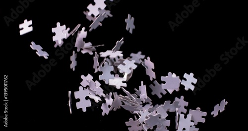 White puzzle pieces falling down whirling in slow motion on a black background