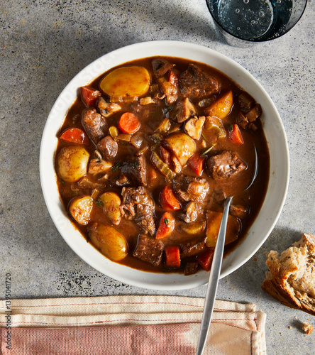 Hearty Beef stew in bowl on table with bread