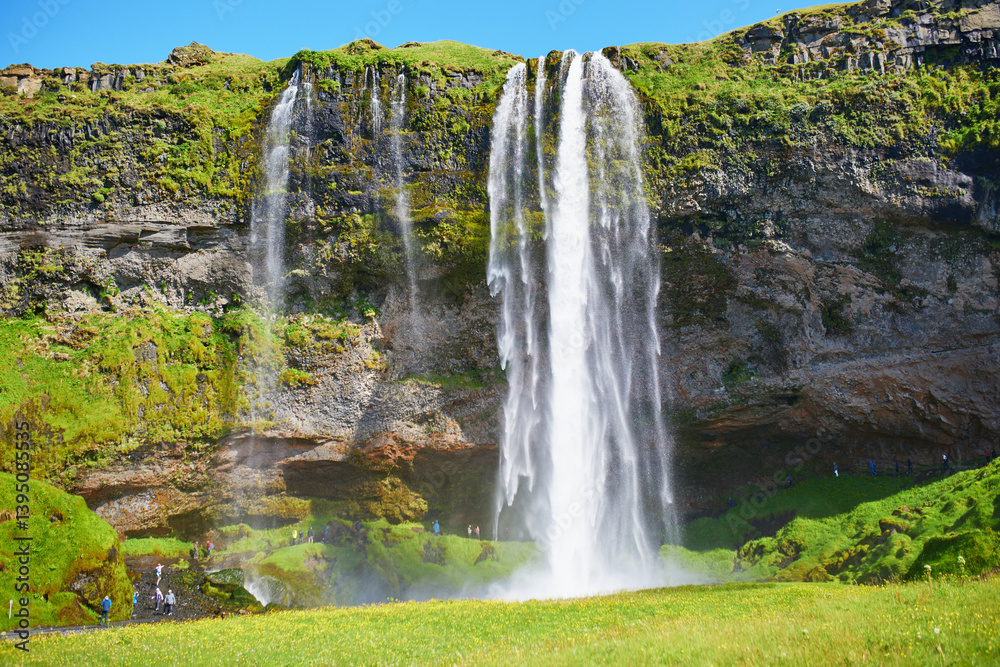 Scenic view of Seljalandsfoss, one of the biggest waterfalls of Iceland, with rainbow. Scenic view of Seljalandsfoss, one of the biggest waterfalls of Iceland, with rainbow.