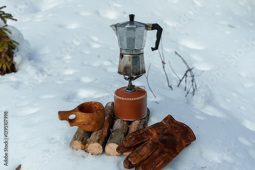 Coffee is being prepared on a gas stove during a winter hike. Gear for making coffee in the outdoors.