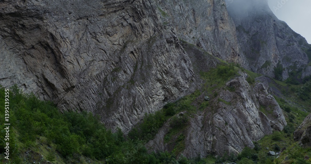 Deep cleft covered with greenery, between sheer cliffs. The tops of the mountains are covered with thick clouds. Daylight video Deep cleft covered with greenery, between sheer cliffs. The tops of the mountains are covered with thick clouds. Daylight video