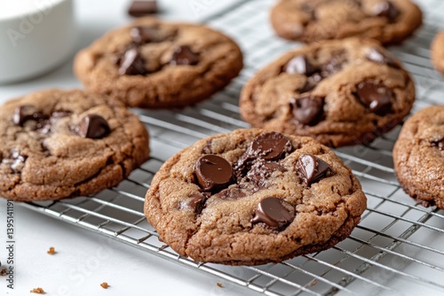 This mouthwatering image showcases a batch of freshly baked chocolate chip cookies cooling on a wire rack, with gooey chocolate chips melting on top for a delicious treat.