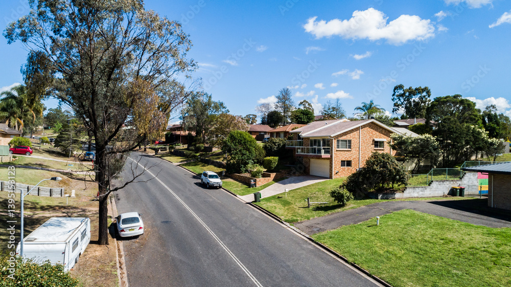 Double lines on road of suburban area with houses and parked cars Double lines on road of suburban area with houses and parked cars