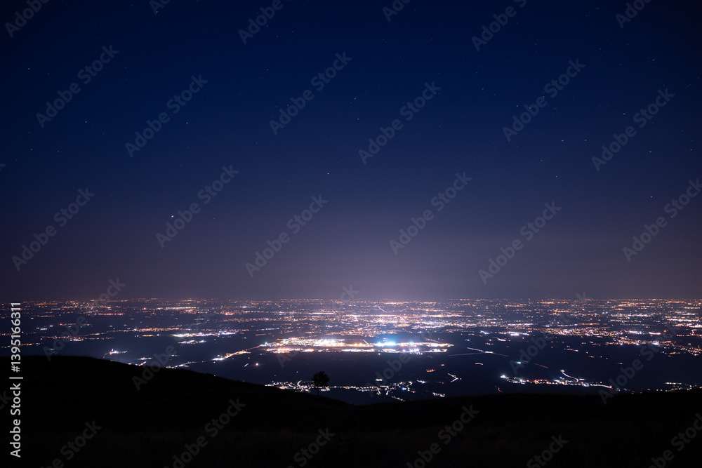 panoramica notturna dalle alture di Piancavallo sulla vasta area urbana in pianura intorno alla città di Pordenone, in Friuli Venezia Giulia, nell'Italia nord-orientale