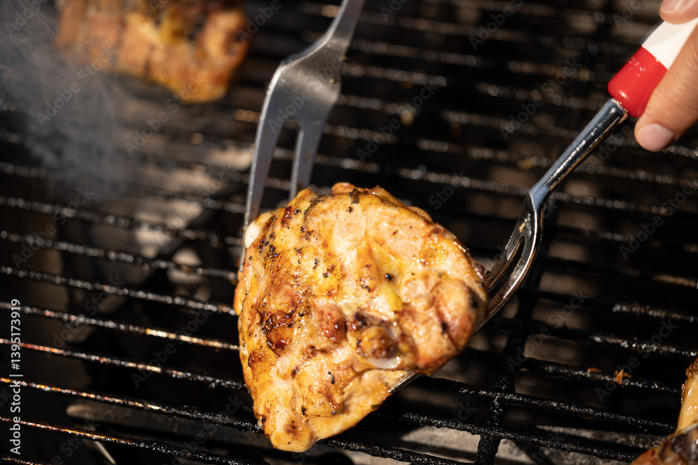 pezzo di carne di pollo mentre viene girata e cucinata su una griglia